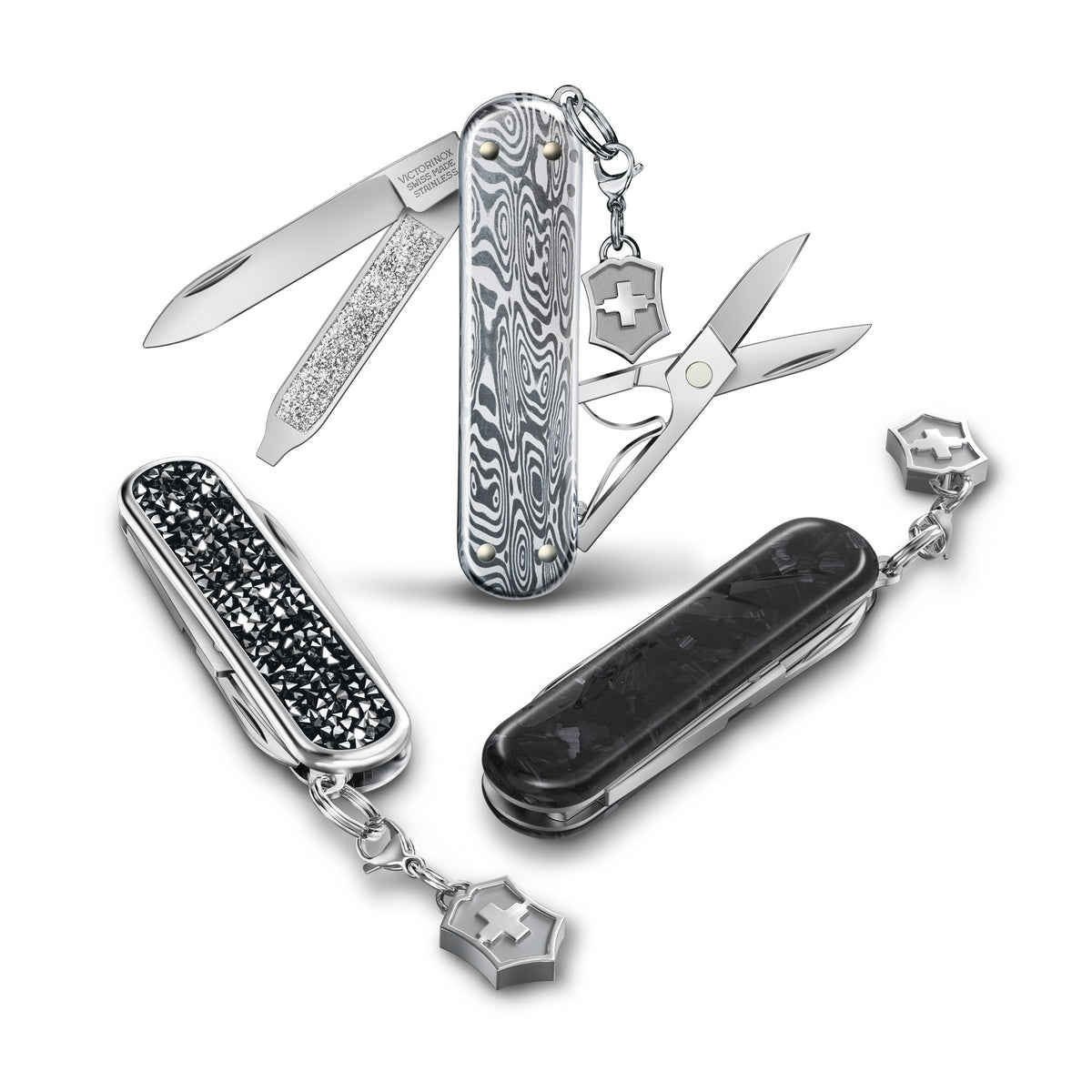 Compact multi-tool with opened blades, black crystal scales, and keyring charms