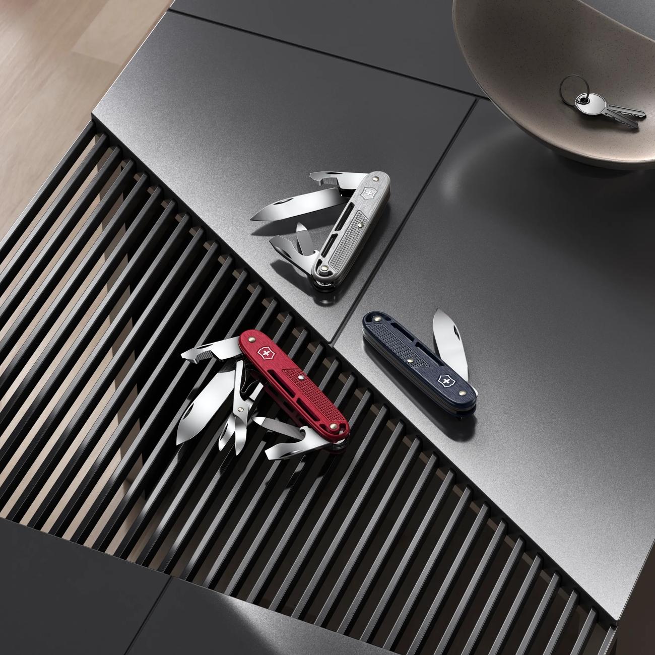 Alox multitools in red, dark blue, and silver with blades and tools