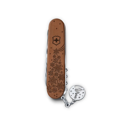 Swiss Army knife with wooden handle and floral pattern on a white background